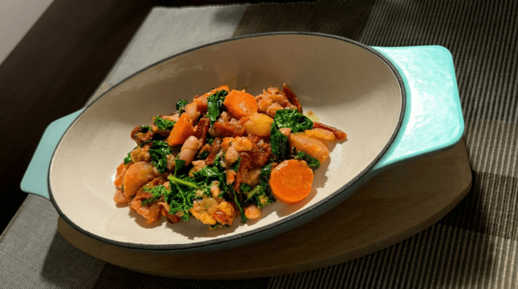 Ribollita Tuscan soup with Cannellini beans, kale, carrots, and tomatoes in a light green bowl